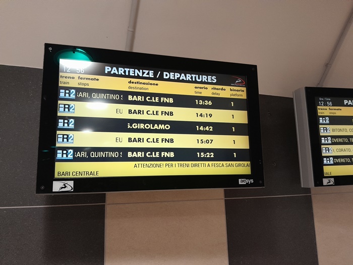 Electronic departure board at Bari Aeroporto showing next trains to Bari Centrale