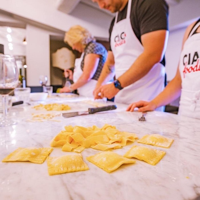 Hands shaping fresh ravioli during a pasta-making class at Ciao Florence cooking school in Italy