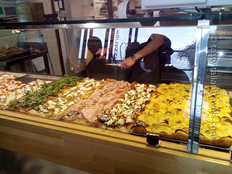 Enjoying pizza on a Rome food tour Tasting richly topped slices of pizza was one of the favourite parts of the Roman food tour in Prati