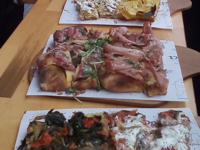 Pizza al taglioâRomeâs ultimate street food with bold, fresh toppings Slices of pizza al taglio with crispy potatoes and creamy mortadella, sampled during our Rome food tour