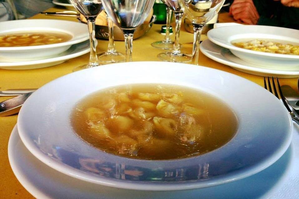 Tortellini al brodo – the iconic and beloved dish that shines on every Bologna food tour A bowl of steaming tortellini al brodo, traditional stuffed pasta served in a clear, flavourful broth, a true culinary star of Bologna