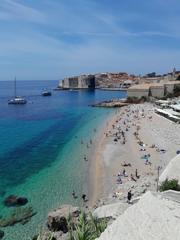 Banje Beach in Dubrovnik stuns with crystal-clear water, fine gravel shores, and a backdrop of lush pine trees—one of Croatia’s most beautiful coastal spots.