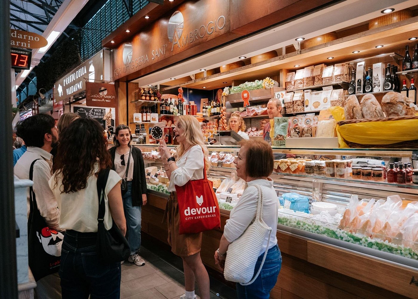Food tour group exploring Mercato Sant’Ambrogio in Florence, surrounded by fresh produce and local vendors