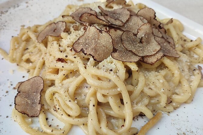 Plate of fresh pasta topped with shaved black truffles, served on the Florence food tour in Oltrarno