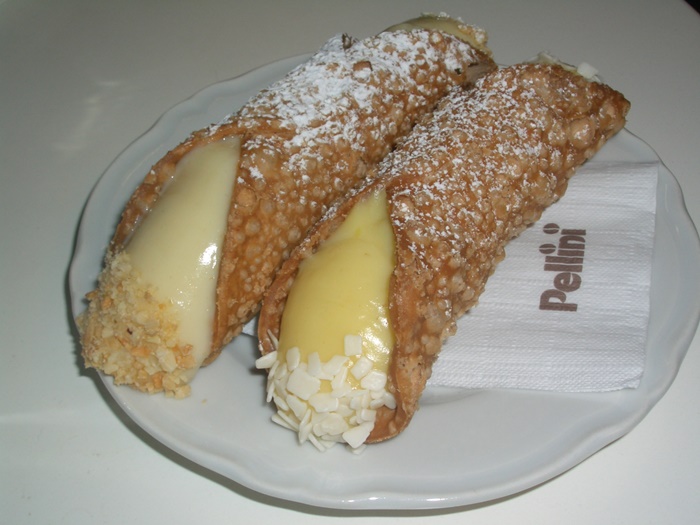 Orange Cream Cannoli at I Dolci di Nonna Vincenza – A Citrusy Delight A plate of Sicilian cannoli filled with smooth, refreshing orange cream, served at I Dolci di Nonna Vincenza