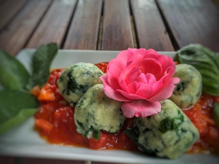 Homemade ricotta gnudi served in a classic Italian tomato sauce