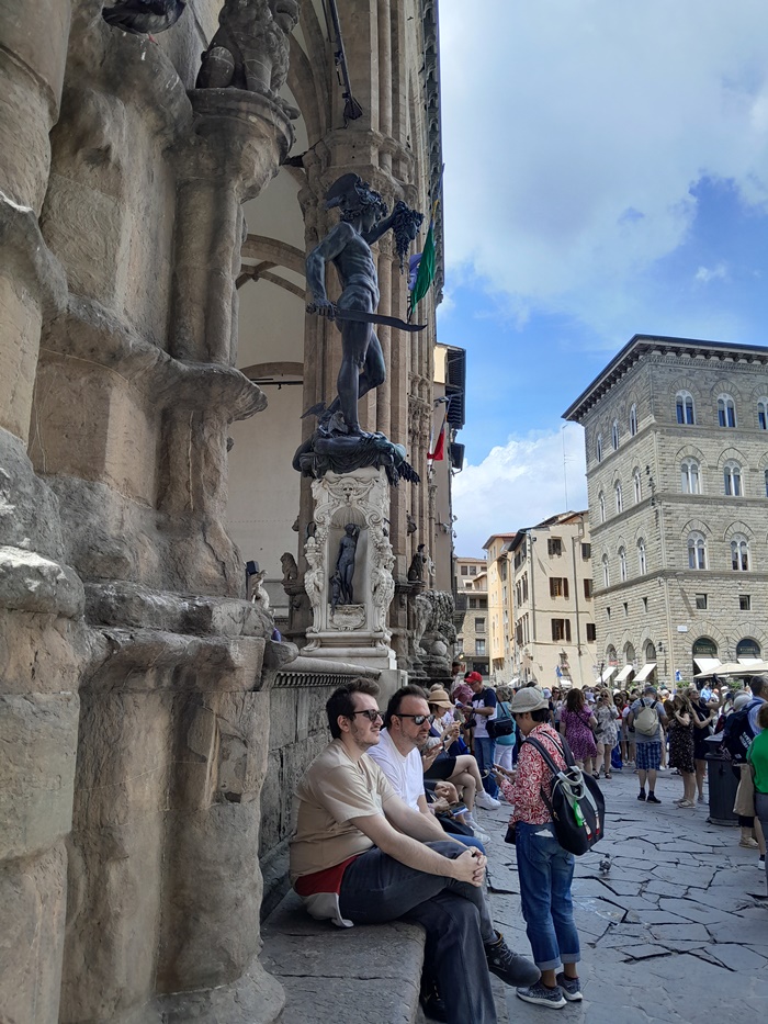 Tourists sitting on the stone benches of Loggia dei Lanci Tourists sitting on the stone benches of Loggia dei Lanci