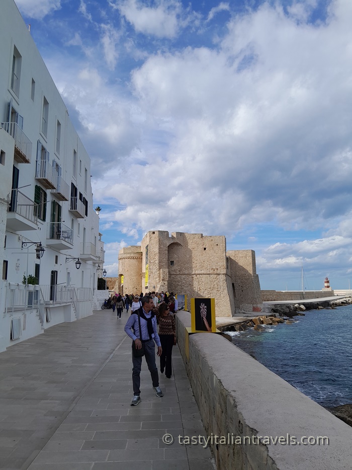 Locals and tourists strolling along Lungomare Santa Maria, Monopoli’s beautiful seaside promenade Locals and tourists walking along Lungomare Santa Maria in Monopoli, Italy, enjoying the sea breeze and coastal views