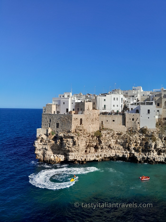 A stunning postcard view of Polignano a Mare, with whitewashed houses perched on dramatic cliffs overlooking the turquoise Adriatic Sea