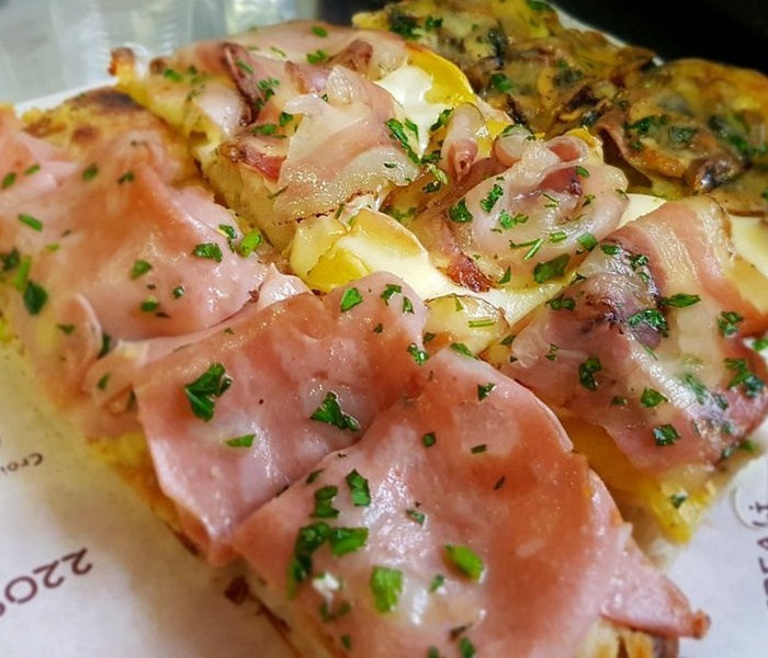 Slice of pizza al taglio from Bonci Pizzarium, known for its high-quality ingredients and creative toppings