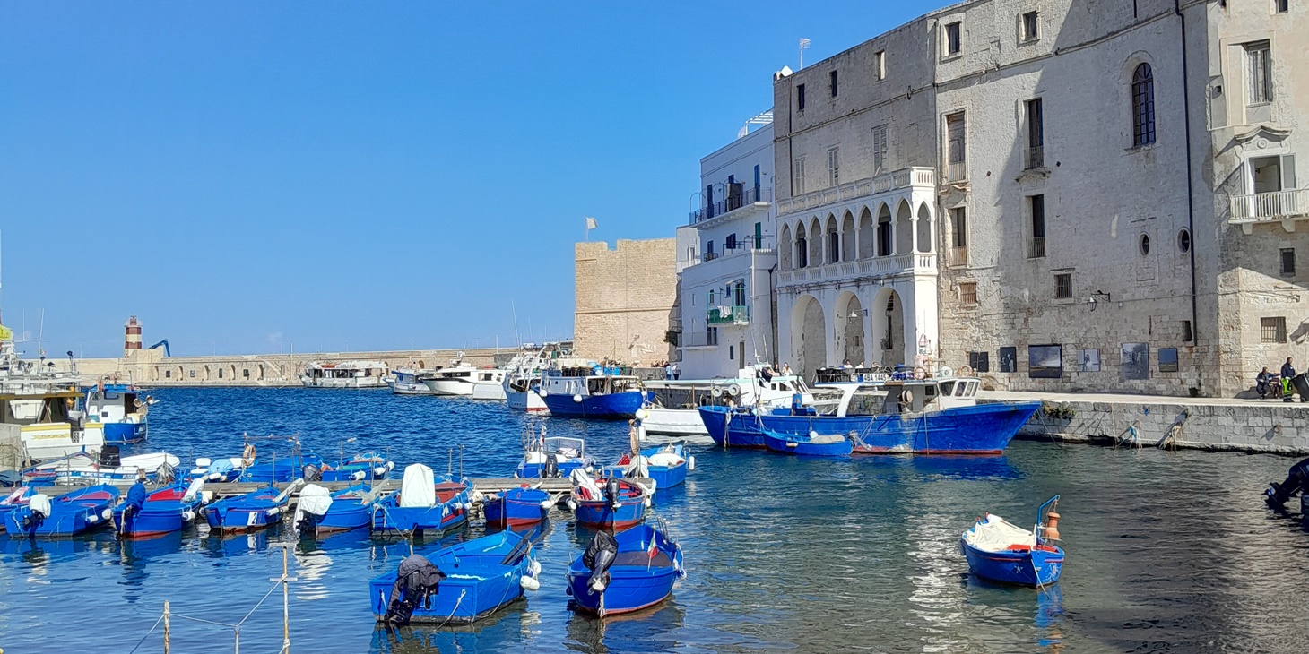 Monopoli Porto Antico with fishing boats (gozzi) Blue fishing boats (gozzi) in the old harbour of Monopoli, Puglia