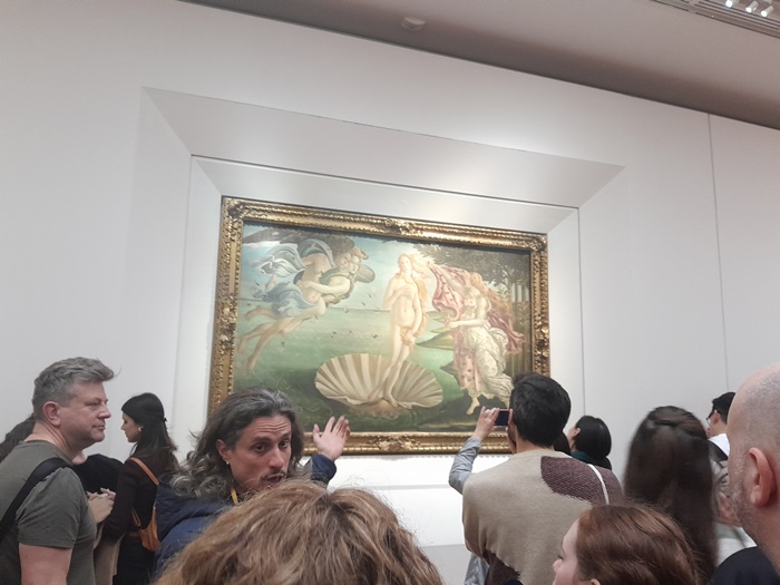 Tour guide sharing the story of the Birth of Venus during a Uffizi Gallery tour