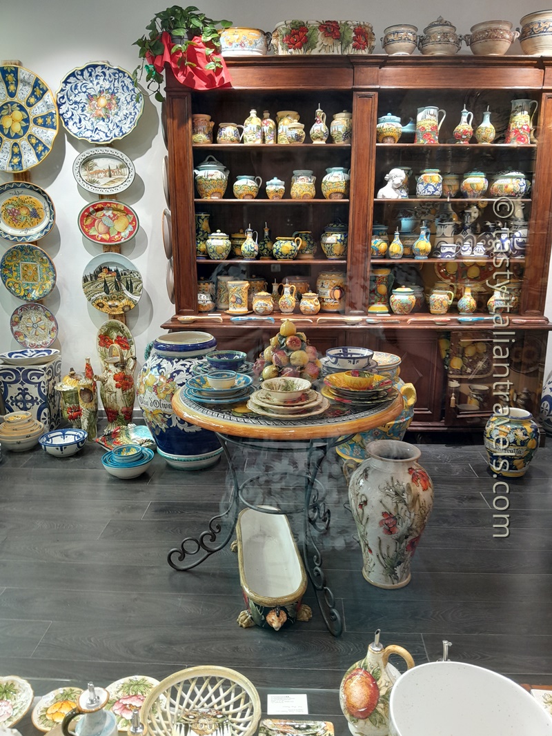 Colorful hand-painted Italian ceramic bowls and plates displayed in a souvenir shop in Florence