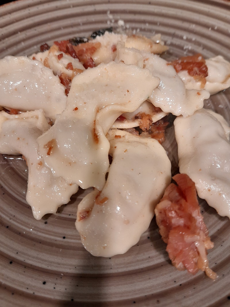 Plate of casoncelli alla Bergamasca, traditional stuffed pasta from Bergamo, served with pancetta, sage, and butter sauce