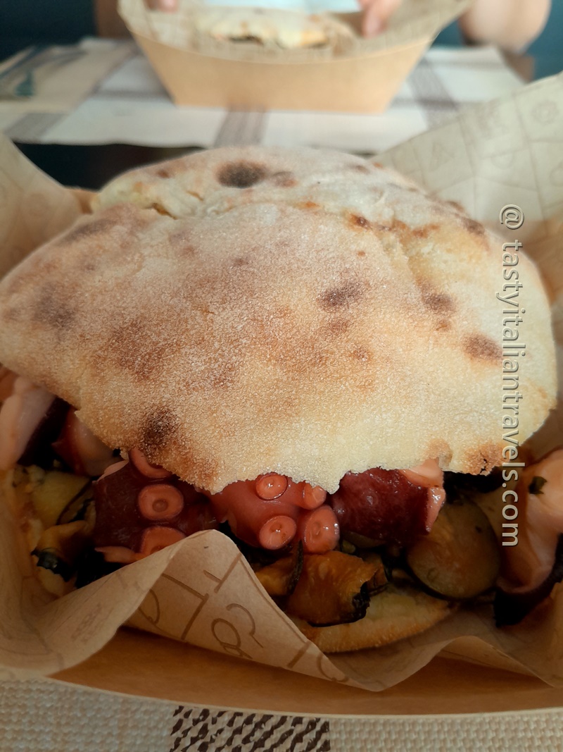 A freshly made puccia filled generously with grilled octopus and zucchini